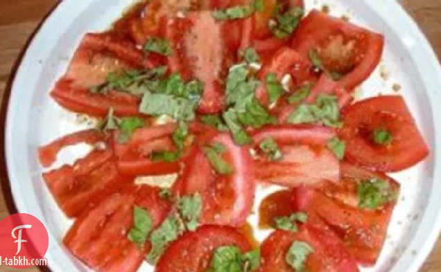 سلطة طماطم مقطعة مع نبات الكبر والريحان