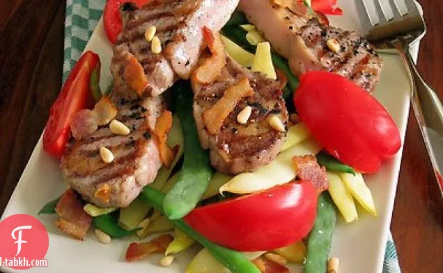 شرائح لحم غنم مشوية ، فاصوليا و طماطم مع لحم الخنزير المقدد الدافئ