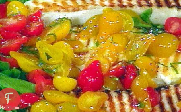 شرائح لحم الهلبوت المشوية على سرير من الجرجير مع سلطة الطماطم والجريمولاتا