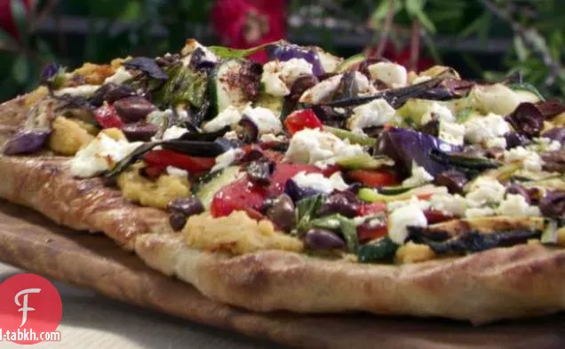 بيتزا مشوية مع الحمص الحار والخضروات وجبن الماعز والزيتون الأسود
