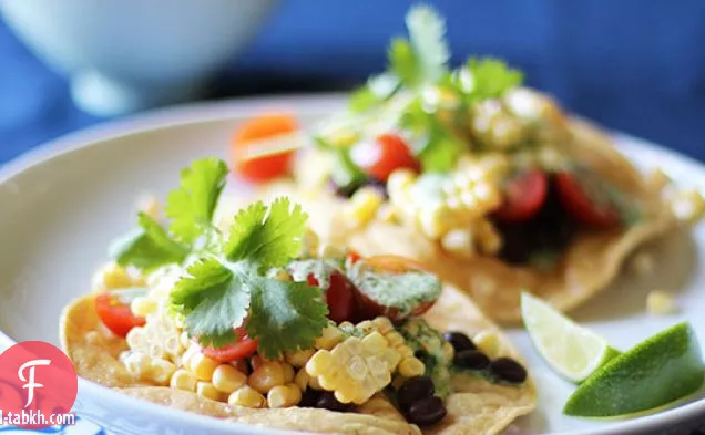 توستادا الذرة والطماطم والفاصوليا السوداء مع دريس الكزبرة الكريمية